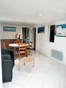 un soggiorno con un tavolo e una sedia di Maison charmante à Trédaniel avec jardin et terrasse a Trédaniel Altre 13 foto