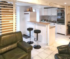 a living room with a couch and a kitchen at Maison de charme à Brantôme en Périgord avec piscine partagée in Brantôme
