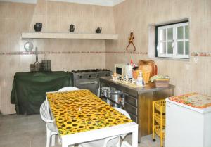 a kitchen with a table and a stove and a table and chairs at Spacious house with mountain view in Vila Fernando in Vila Fernando