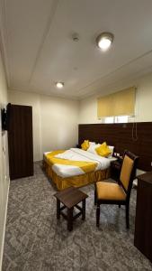 una habitación de hotel con una cama y una silla en فندق مضياف الافانين, en La Meca