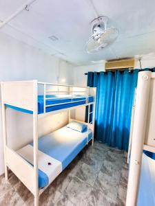 a bunk bed room with two bunk beds and blue curtains at HOSTEL KATUNAYAKE At COLOMBO AIRPORT TRANSIT in Katunayake