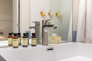 een badkamerbar met flessen essentiële oliën en een wastafel bij The Conway by AvantStay Modern Comfort Near Downtown Nashville in Nashville +278 foto's