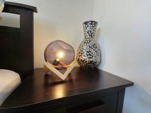 a table with a glass globe and a vase on it at Bright & Cozy Studio - Private Access & Full Privacy in Auckland