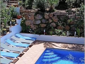 a group of lounge chairs next to a swimming pool at Flores in Begur