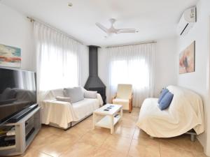 a living room with a couch and a tv at Flores in Begur