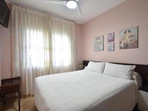 a bedroom with a white bed and a window at Flores in Begur +16 photos