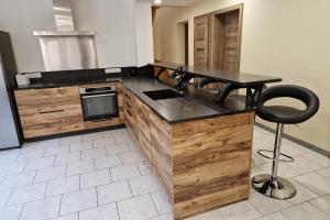 a kitchen with a counter with a sink and a stool at Gîte 3 étoiles jusqu'à 12 pers in Fresse-sur-Moselle