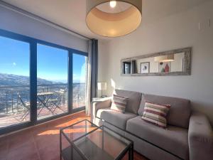 Una sala de estar con un sofá y una mesa de cristal. en SN Vista Nevada Suites, en Sierra Nevada
