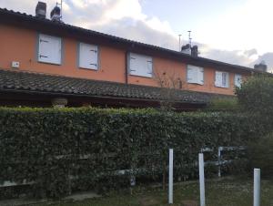un edificio con finestre bianche e una siepe di La Casetta degli Innamorati a Sutri