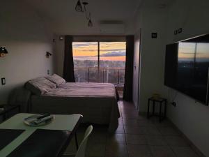 een kamer met een bed, een televisie en een tafel bij Monoambiente moderno e inteligente en B Sur Cochera Precio en USD in San Miguel de Tucumán