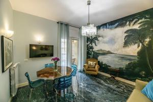 una sala da pranzo con tavolo e un dipinto sul muro di Tu chiamale emozioni 3 suite a Roma