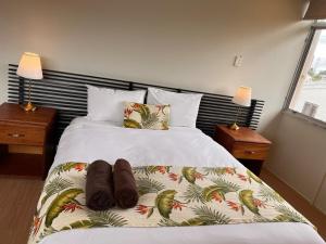 ein Bett mit zwei Paar Schuhen drauf in der Unterkunft Kidsfirst Apartment 5- Duncan Road, Suva City in Suva