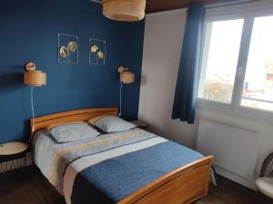 a bedroom with a bed with blue walls and a window at Appart Le Crotoy Bécassine 50mètres Plage,centre. in Le Crotoy