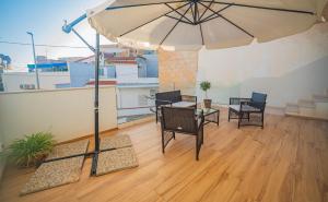 a patio with a table and an umbrella on a balcony at ITACA, casa vacanze a Casuzze in Marina di Ragusa