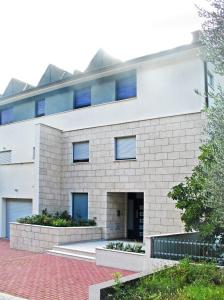 a white brick building with blue windows at Apartments Villa Ceres in Klek