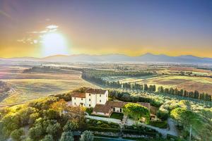 une maison sur une colline avec le soleil en arrière-plan dans l'établissement Agriturismo Morisfarms - Santa Laura, à Cura Nuova