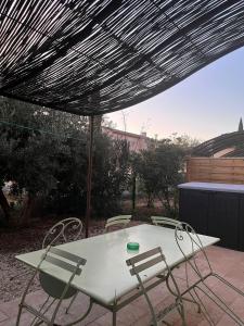 un tavolo e delle sedie sotto un ombrellone in un patio di Maison 4 ou 6 personnes au cœur Corbières a Saint-Laurent-de-la-Cabrerisse Altre 19 foto
