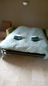un letto con due cuscini sopra in una camera da letto di Maison 4 ou 6 personnes au cœur Corbières a Saint-Laurent-de-la-Cabrerisse