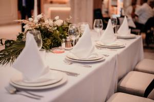 un tavolo bianco con piatti e tovaglioli sopra di Hotel Almanas a Sarajevo