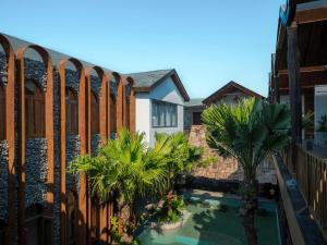 a balcony with a swimming pool and palm trees at Ailee Villa&Hotel TamCoc in Ninh Binh