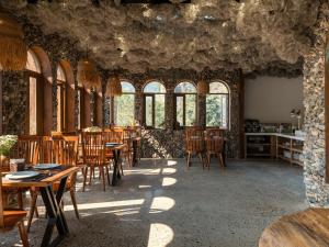 a dining room with tables and chairs and windows at Ailee Villa&Hotel TamCoc in Ninh Binh