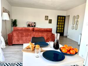 a living room with a table with blue plates and fruit at Les Toits de Muret in Muret