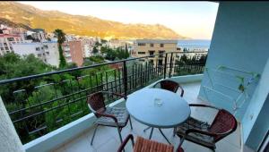 a balcony with a table and chairs and the ocean at Sea & Mountain View Apartment in Budva