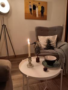 a candle on a table in a living room with a couch at Ferienwohnung Engelsthann in Hilders