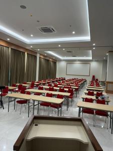a conference room with tables and chairs and a screen at Lakeside TELL Cikarang in Ceper 2