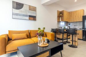 a living room with a yellow couch and a table at Gianna's Apartments in Bendevís