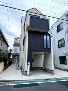 un edificio blanco y negro en una calle de la ciudad en Katsushika House柴又, en Tokio