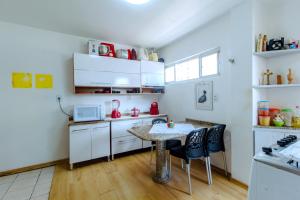 eine kleine Küche mit einem Tisch und Stühlen in der Unterkunft Duplex Confort boa viagem perto de tudo in Recife + 9 Fotos