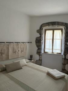 a bedroom with a large bed and a window at B&B Pudzones in Santu Lussurgiu