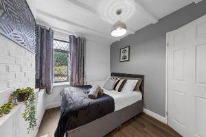 a bedroom with a bed and a window at Cosy 3-bed House Free Parking and Hot tub in Chatham