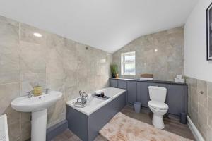a bathroom with a tub and a sink and a toilet at Cosy 3-bed House Free Parking and Hot tub in Chatham +18 photos