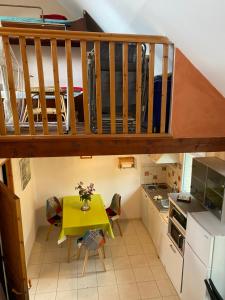 l'ESCALE في سان-بير-سور-مير: مطبخ صغير مع طاولة صفراء وسرير بطابقين