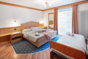 Ένα ή περισσότερα κρεβάτια σε δωμάτιο στο Garni Prà Fiori