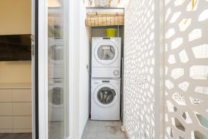 una lavanderia con lavatrice e asciugatrice di Lumen - Downtown Vibes a Cagliari