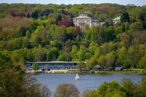 a sailboat in the water in front of a building at Neues und zentrales Apartment im Ruhrgebiets-Style von STAY YOUR WAY in Essen