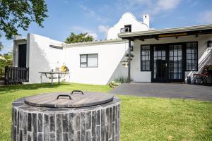 una casa blanca con una mesa en el patio en Faraway Cottage 3 Gables Self catering Swellendam, en Swellendam