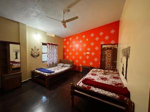 Habitación con 2 camas y paredes rojas. en Shreeniketana stay, en Mādangeri