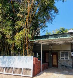 an old house with a white fence and trees at Leela Villa - Ancient Redstone Escape in Panchgani