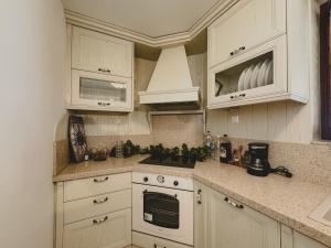 a kitchen with white cabinets and a stove top oven at Pelion Green House in Ano Volos