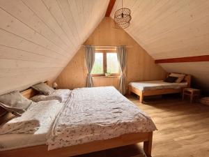 a attic bedroom with two beds and a window at Chata Michaela Beskydy in Čeladná +10 photos