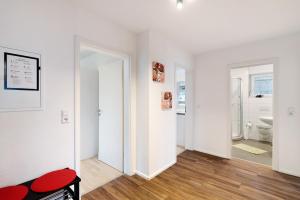 a white room with a red chair and a bathroom at Hildas Plätzchen in Oberkirch +17 photos