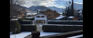 un patio cubierto de nieve con setos frente a una casa en Aparthotel Terrassenhof, en Bad Wiessee