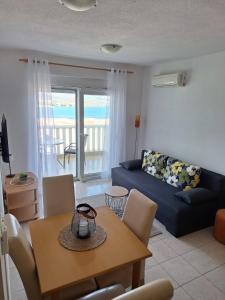 a living room with a blue couch and a table at Apartman Fishers View in Trogir