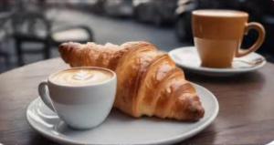 Zwei Teller Croissants und eine Tasse Kaffee auf einem Tisch in der Unterkunft Namastè Ca Biasca in Biasca