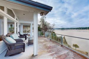 a porch with chairs and a view of the water at East Haven Lodge in Shelton