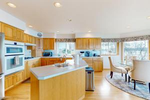 a kitchen with wooden cabinets and a table and chairs at East Haven Lodge in Shelton